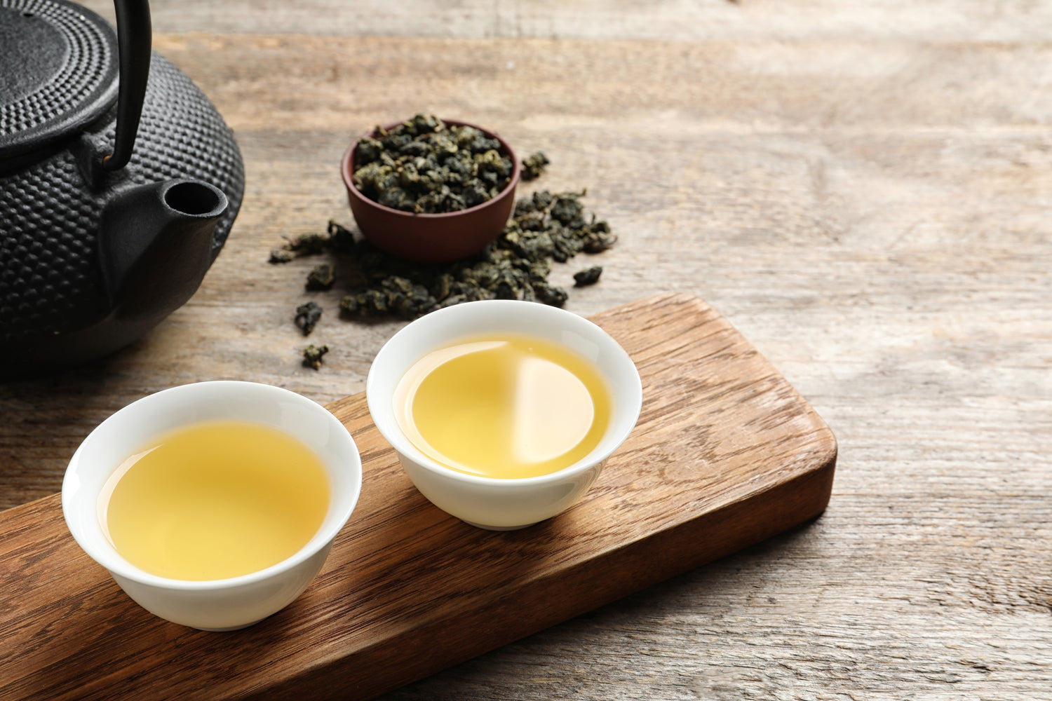 2 cups of iron goddess (tie guan yin) tea bring served.