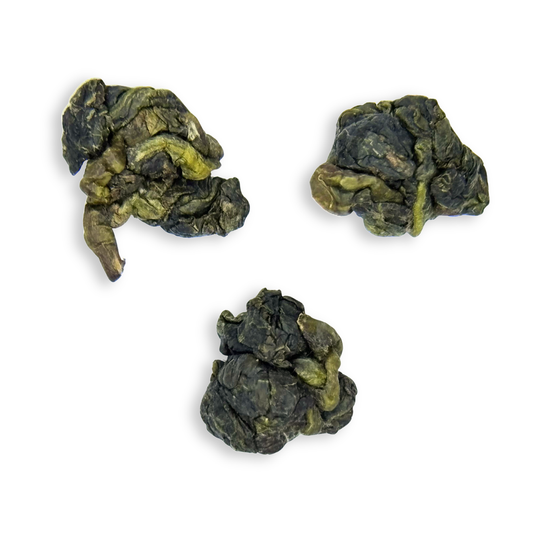 Three dried milk oolong tea leaves on a white background
