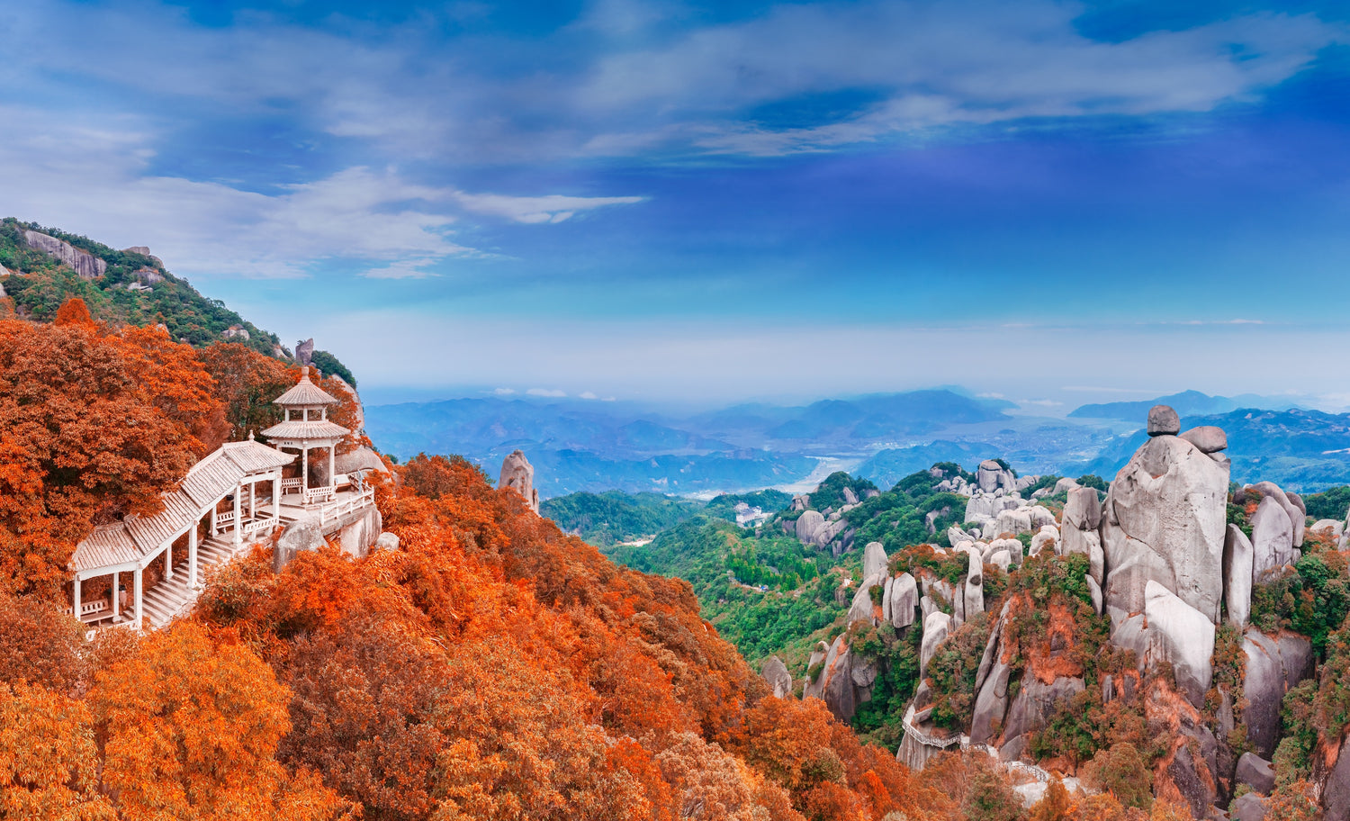 a view from on top of taimu mountain in fujian china, showcasing the fall foliage and unique rock formations